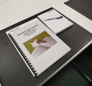 Het handboek bij de workshop 'Audiodescriptie schrijven voor film en tv' dat de deelnemers na afloop mee naar huis krijgen en enkele Officenter-gadgets.